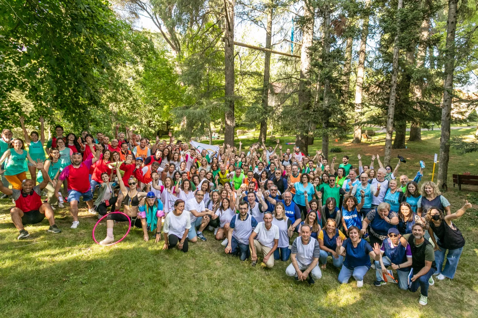 Grupo numeroso celebrando entre los árboles del jardín en una jornada de empresa