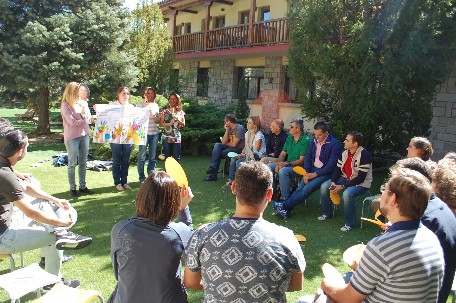 Dinámica de equipo en círculo al aire libre frente a una casa rural